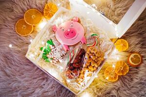 Christmas or New Year gift box with candies, gingerbread cookies, candieshmallows, candies in the form of a pig photo