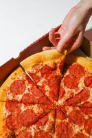 Pepperoni pizza in a cardboard box on a white background. photo