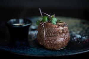 Beef steak with sauce on a blue plate. Selective focus. photo