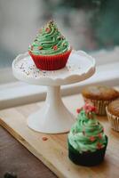 Cupcakes with green cream and sprinkles on a white stand photo
