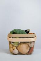 Vegetables in a wicker basket on a gray background. photo