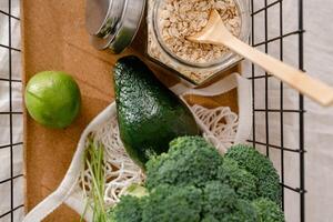top view of glass jar with oat flakes, avocado and lime on wooden table photo