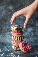 rosquillas con chocolate Crema y asperja en un oscuro antecedentes foto