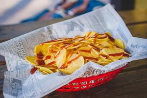 Crispy potato chips with ketchup and mayonnaise on wooden table photo