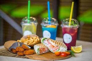 Sandwiches with salmon, vegetables and french fries on a wooden board photo