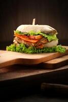 Sandwich with chicken, tomato and lettuce on a wooden board. photo