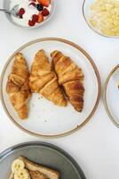 desayuno con cruasanes, cereales y frutas en mesa foto