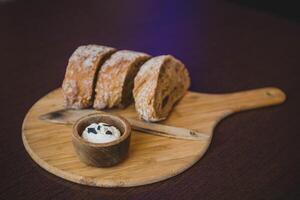 Bread and butter on a wooden board in a cafe. Selective focus. photo