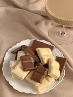 chocolates in a plate on a beige background, top view photo