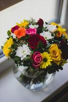 Bouquet of multicolored roses in a glass vase photo