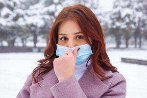 pretty young woman in winter park, red haired girl in the park in winter photo