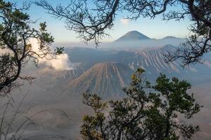 Spectacular view of Mount Bromo at dawn view look through the natural frame. This is an active volcano part of the Tengger massif, in East Java, Indonesia. photo