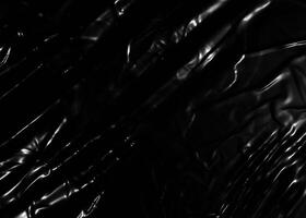 Wrinkled plastic wrap texture on a black background photo