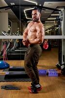 bodybuilder training his muscles in gym, bodybuilder training with dumbbell photo