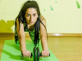 woman doing fitness exercise, young woman doing fitness exercises in fitness club photo