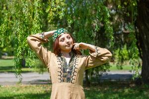 Armenian young woman in traditional clothes in the nature in summer photo