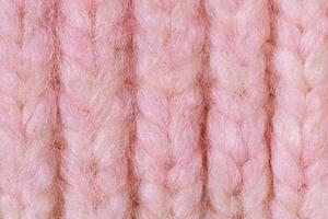 Terry knitted texture as a macro photo background. Pink and beige detail of a knitted item.