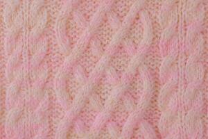 Pink and beige detail of a knitted item. Terry knitted texture as a macro photo background.