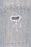 Denim fabric as a background. Macro photo of an item of clothing, jeans with a patch.