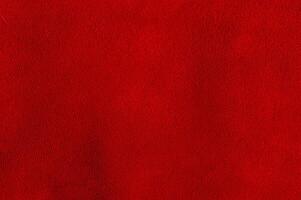 The background is red velvet. Macro photo of natural red suede. Texture of suede leather.