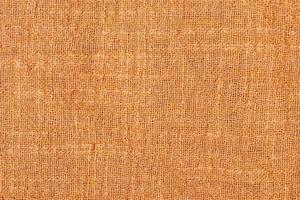 Natural brown burlap fabric macro photo. The fabric as a background is brown textile texture. photo