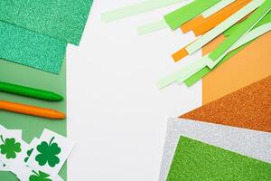 Irish flag made from color paper with cut out shamrock clover crayons and glitter paper photo