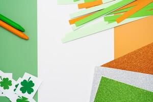 Irish flag made from color paper with cut out shamrock clover crayons and glitter paper photo