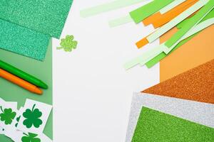 Irish flag made from color paper with cut out shamrock clover crayons and glitter paper photo