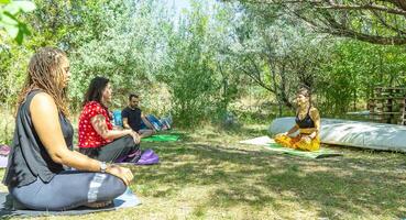 group of people doing yoga exercise in the park, womans relaxing in the park photo