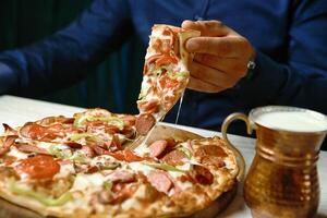 Person Cutting Pizza With Pizza Cutter photo