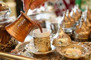 Person Pouring Tea Into Cup on Tray photo