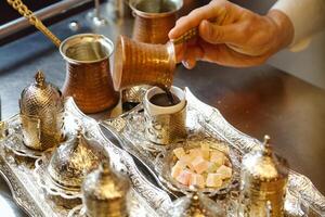 Person Pouring Coffee on Silver Tray photo