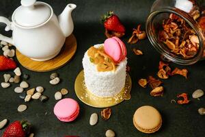 White Cake on Table Next to Tea Pot photo