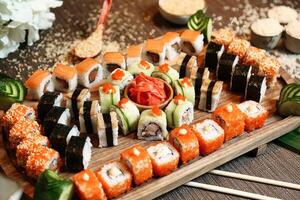 Wooden Tray Covered in a Variety of Sushi Rolls photo