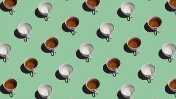 Pattern with many tea cups and empty cups animated on light green background. Tea mugs with hot drink move in different directions. 4K video