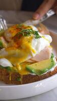 Close up of a dish with eggs, ham, and avocado on a toast video