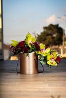 Metal Container With Flowers on Wooden Floor photo