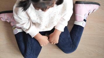 child sitting W posture on the floor . video