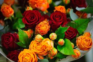 Vibrant Red and Orange Rose Bouquet With Green Leaves photo