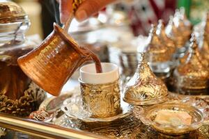 Person Pouring Tea Into Cup on Tray photo