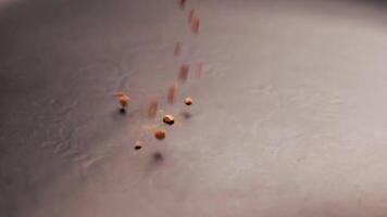 Instant Coffee granules drop in slow motion onto a black surface and form a small pile video