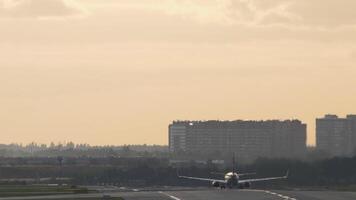 Rückseite Aussicht von ein Flugzeug nimmt aus. Passagier Flugzeug nehmen aus und aufsteigend. bunt Sommer- Sonnenuntergang. statisch Schuss, echt Zeit. der Verkehr beim Flughafen beim Dämmerung video