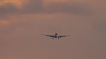 Jet plane with unrecognizable livery approaching landing in pink sunset video