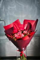 Vibrant Red Flowers in Glass Vase photo