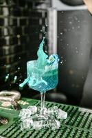 Person Pouring Blue Liquid Into a Glass. photo