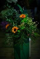Green Vase Overflowing With Yellow Flowers photo