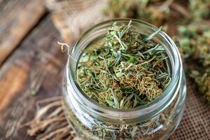 AI generated Cannabis Buds in Jar Closeup with Fresh Leaves photo