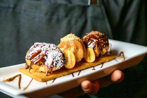 Person Holding a White Plate With Donuts photo