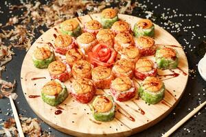 Wooden Plate Topped With Assorted Sushi Rolls photo