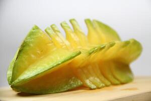 slices of starfruit well arranged on wooden cutting board photo